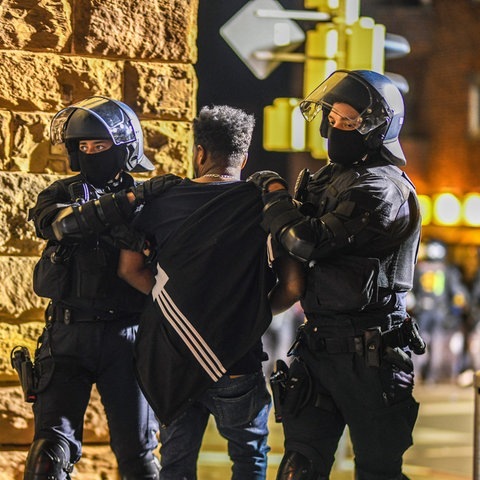 Ein Mann, der zu einer Gruppe von Menschen gehört, die nach Ausschreitungen bei einer Eritrea-Veranstaltung von Polizeikräften eingekesselt wurden, wird von Polizisten abgeführt. (Foto: dpa Bildfunk, picture alliance/dpa | Jason Tschepljakow)