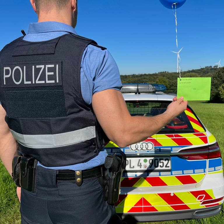 Beamter der Polizei Montabaur hält die Einschulungs-Karte mit Luftballon  (Foto: Polizeipräsidium Koblenz)