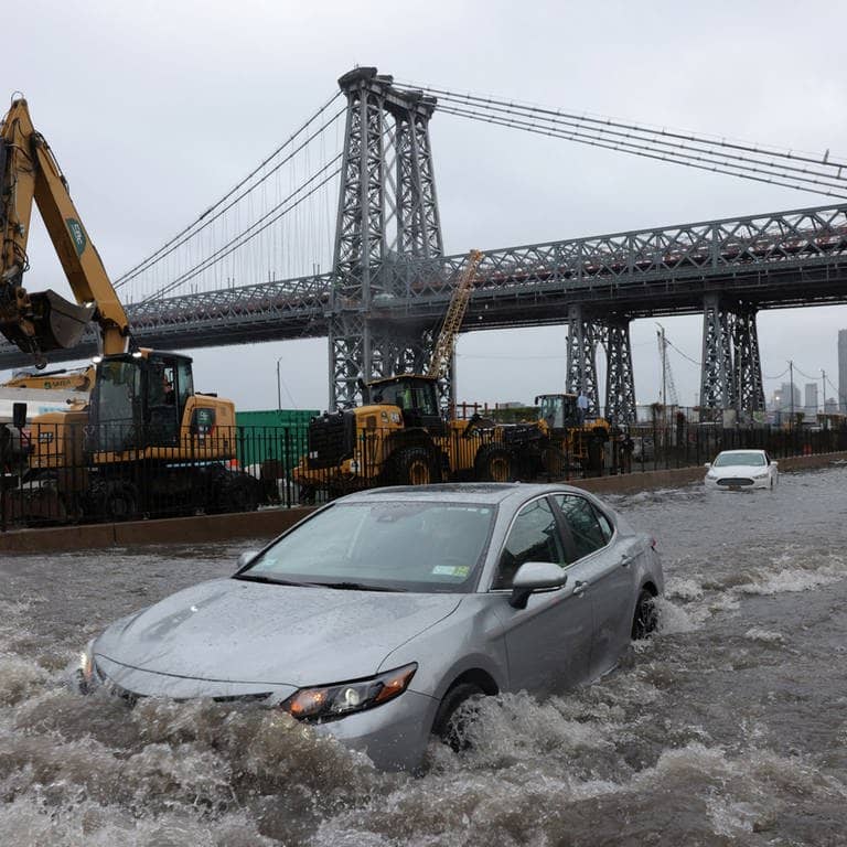 Ein Auto fährt über eine überflutete Straße vor der Williamsburg Bridge in New York City (Foto: Reuters, REUTERS/Andrew Kelly)