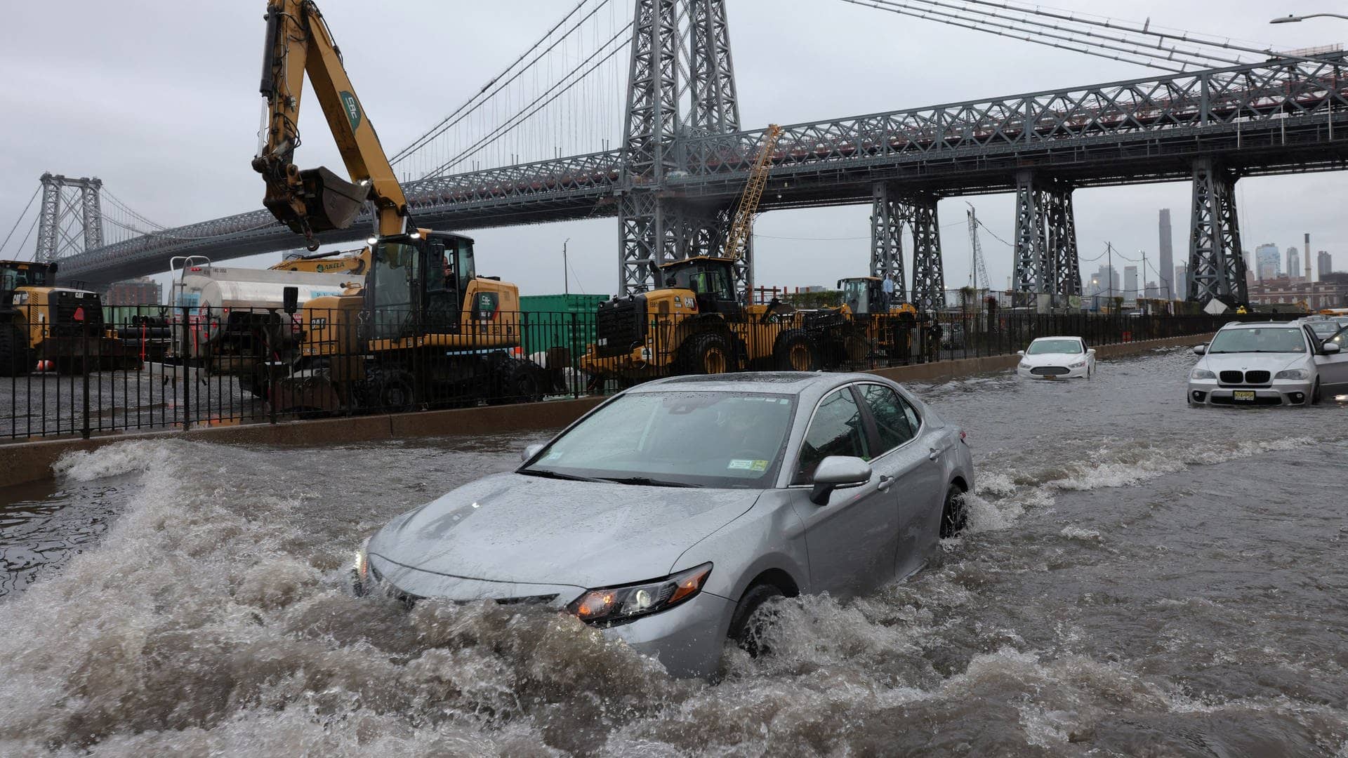 Ein Auto fährt über eine überflutete Straße vor der Williamsburg Bridge in New York City (Foto: Reuters, REUTERS/Andrew Kelly)