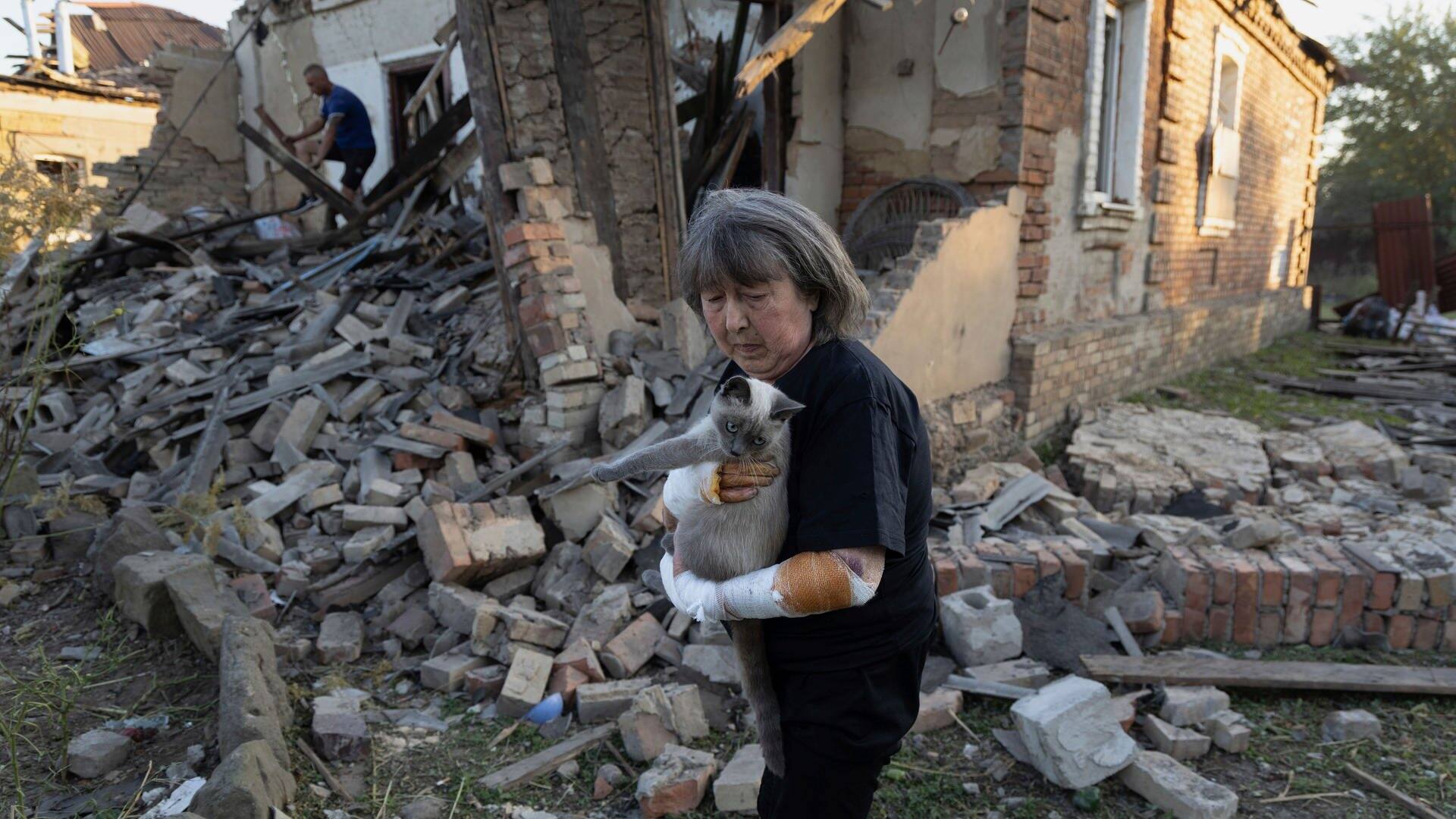 Eine verletzte Frau in der Region Donezk hält ihre Katze im Arm (Foto: dpa Bildfunk, picture alliance/dpa/AP | Alex Babenko)