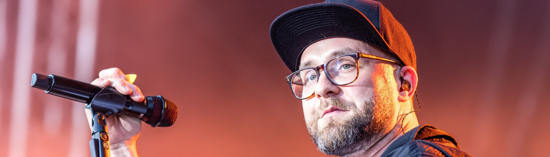 Sänger Mark Forster steht mit einem Mikofon in der Hand bei einem Konzert innerhalb seiner „Open Air Tour 2022“ auf der Bühne im Spreeauenpark.