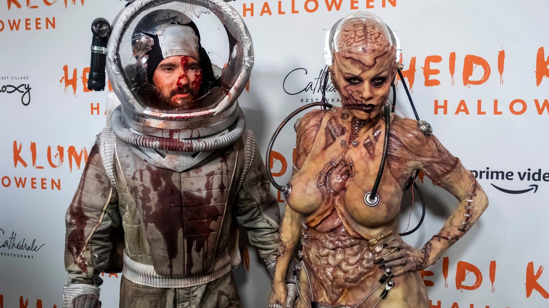 Heidi Klum (r), Model, Moderatorin und TV-Produzentin, und ihr Ehemann Tom Kaulitz, Sänger, stehen als Zombie und blutverschmierter Raumfahrer verkleidet vor ihrer Halloween-Party nebeneinander. (Foto: dpa Bildfunk, picture alliance/dpa/Invision | Charles Sykes)
