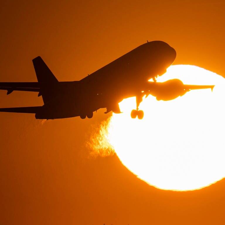 Ein Flugzeug startet im Sonnenuntergang (Foto: dpa Bildfunk, picture alliance/dpa | Boris Roessler)