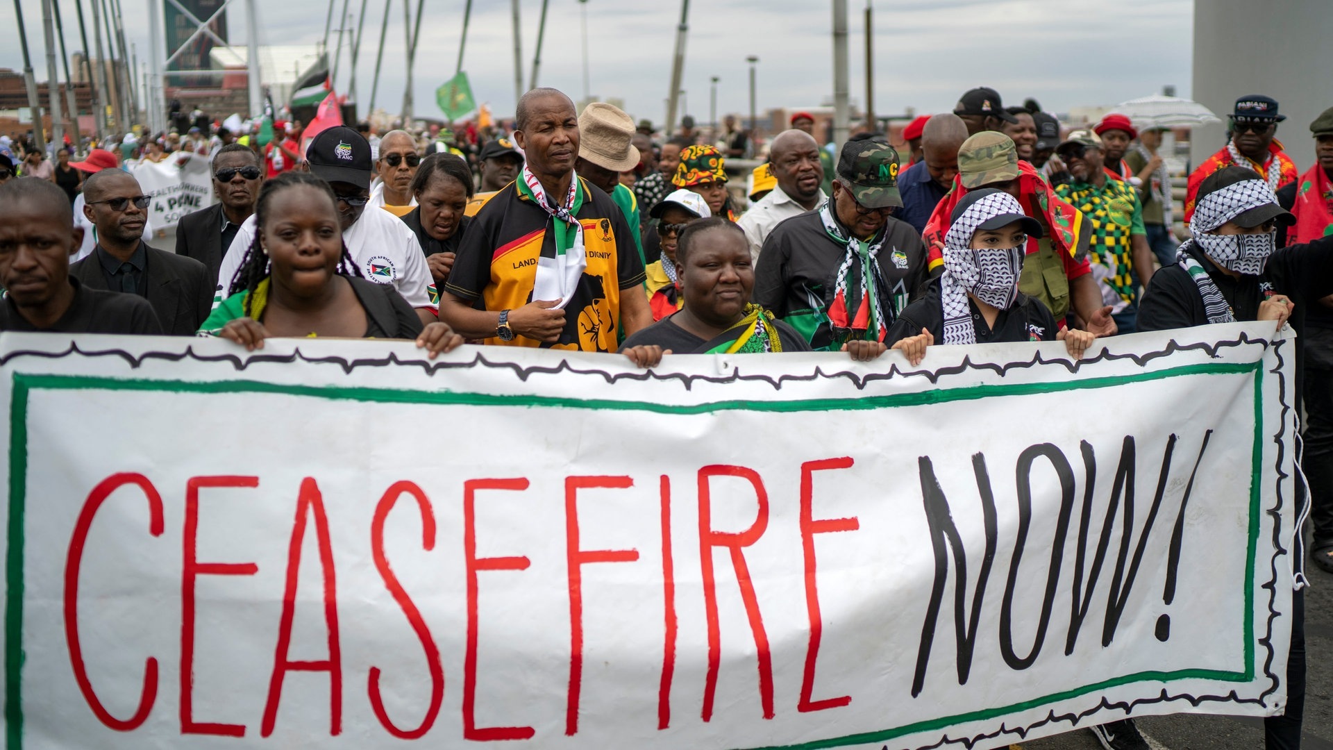 Pro-palästinensische Demonstranten marschieren über die Mandela-Brücke in der Innenstadt und hatlen ein Banner auf dem «CEASEFIRE NOW!» (Waffenstillstand jetzt!) geschrieben steht. Hunderte von Demonstranten protestierten gegen das israelische Vorgehen im Gazastreifen und forderten einen dauerhaften Waffenstillstand. (Foto: dpa Bildfunk, picture alliance/dpa/AP | Jerome Delay)