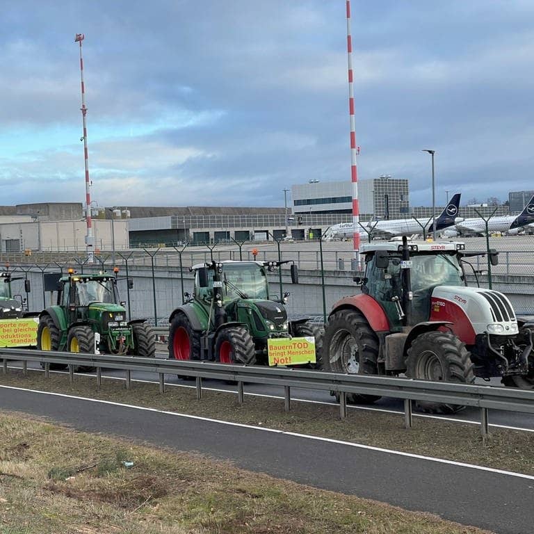 Traktoren fahren auf einer Straße am Flughafen Frankfurt vorbei. Wie ein Polizeisprecher sagte, begaben sich die Bauern am Morgen gegen 6:00 Uhr Richtung Airport. Geplant sei eine Protestfahrt rund um das Gelände. (Foto: dpa Bildfunk, picture alliance/dpa | Mike Seeboth)