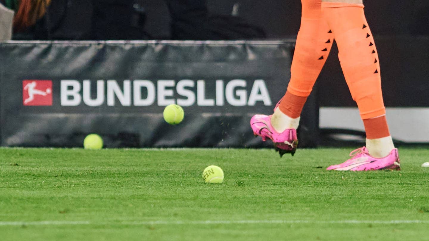 Dortmunds Torwart Gregor Kobel schießt Tennisbälle vom Platz, die Fans aus Protest gegen Investoren in der DFL auf das Spielfeld geworfen haben. (Foto: dpa Bildfunk, picture alliance/dpa | Bernd Thissen)