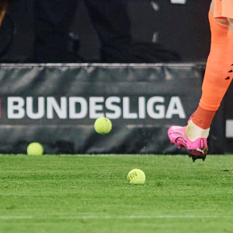 Dortmunds Torwart Gregor Kobel schießt Tennisbälle vom Platz, die Fans aus Protest gegen Investoren in der DFL auf das Spielfeld geworfen haben. (Foto: dpa Bildfunk, picture alliance/dpa | Bernd Thissen)