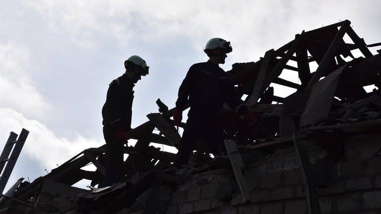 Rettungskräfte räumen die Trümmer zerstörter Häuser nach einem russischen Drohnenangriff weg. (Foto: dpa Bildfunk, picture alliance/dpa/AP | Andriy Andriyenko)