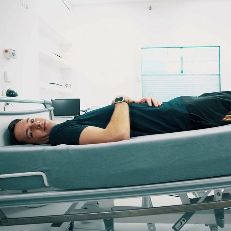 Die DLR führt eine Bettruhestudie durch. Dabei liegt ein Teilnehmer in einem sechs Grad geneigten Bett. (Foto: DLR)