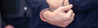 Der Angeklagte im Tankstellen-Prozess wird in Handschellen in den Gerichtssaal gebracht