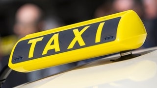 Großes Taxischild auf einem Taxi.