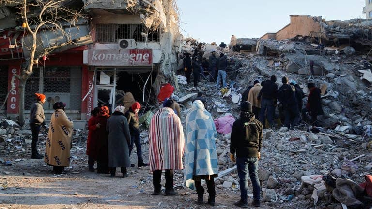 Menschen stehen vor den Trümmern eines Hauses in Kahramanmaras, Türkei. (Foto: Reuters, REUTERS/Dilara Senkaya)
