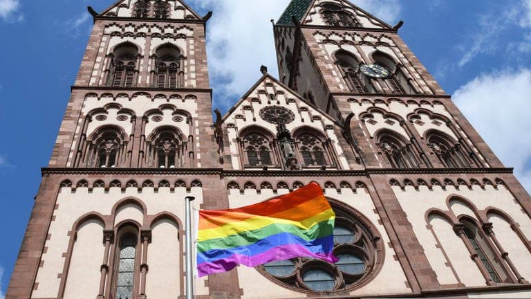 Vor der Freiburger Herz-Jesu-Kirche weht eine Regenbogenfahne.