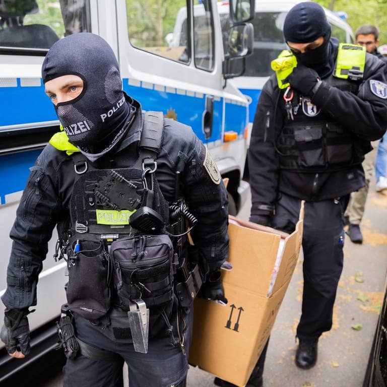 Polizisten tragen während einer Razzia gegen Klimaaktivisten der „Letzten Generation“ einen Karton zu einem Fahrzeug (Foto: dpa Bildfunk, picture alliance/dpa | Christoph Soeder)