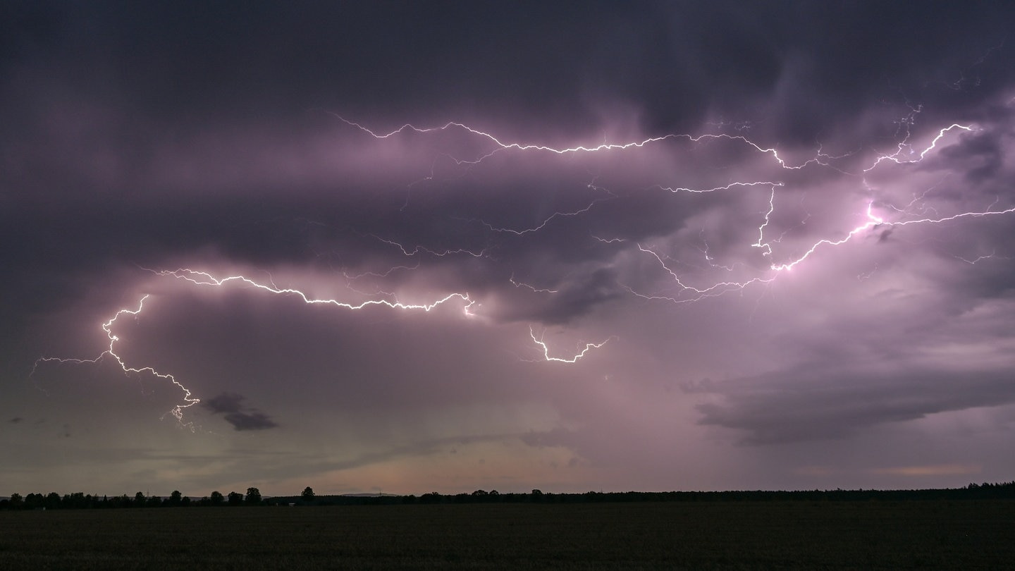 Gewitter: Blitze erhellen die dunklen Wolken über der Landschaft