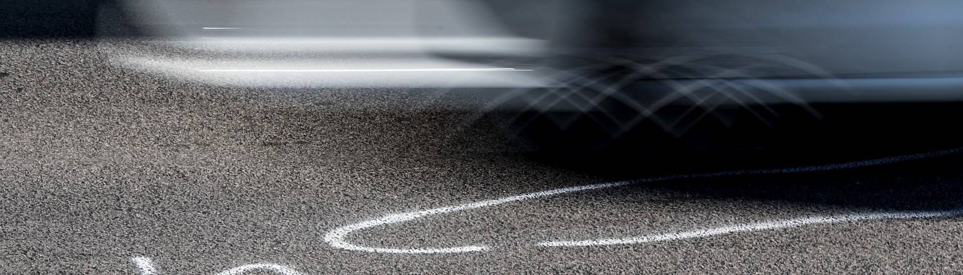 Symbolbild illegales Autorennen: Auto fährt über die Markierungen der Spurensicherung (Foto: dpa Bildfunk, picture alliance / Federico Gambarini/dpa | Federico Gambarini)