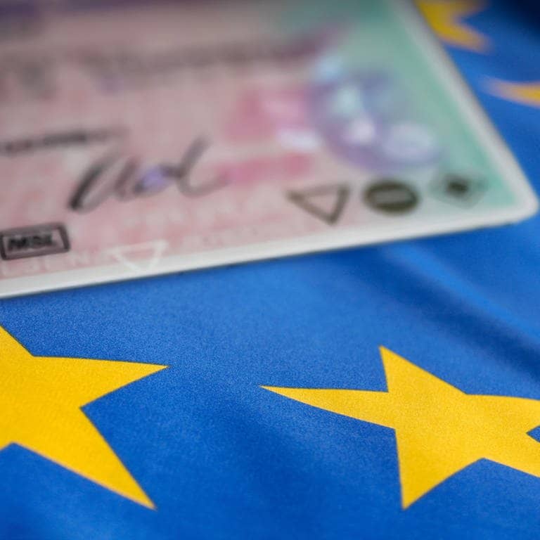 Ein Führerschein liegt auf einer Europaflagge.