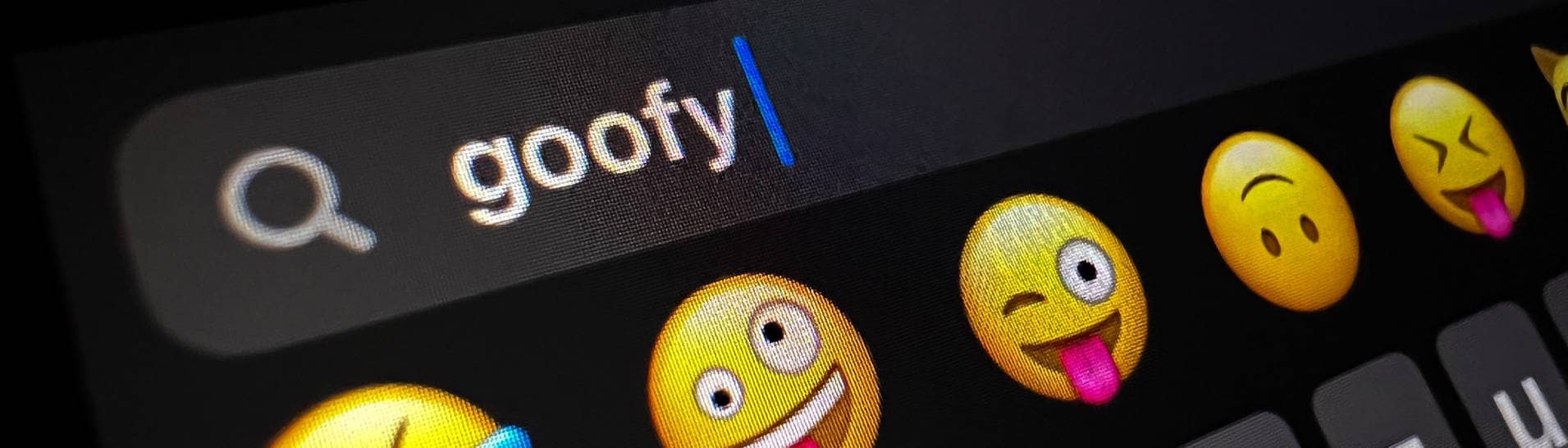 Im Display eines Smartphones ist im Suchfeld für Smileys das Wort „goofy“ zu lesen.