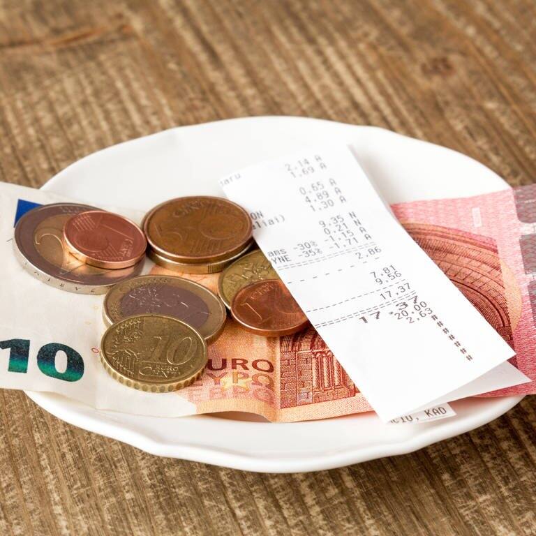 Geld liegt in einem Restaurant auf einem Teller.