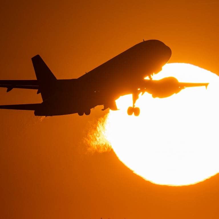 Ein Flugzeug startet im Sonnenuntergang