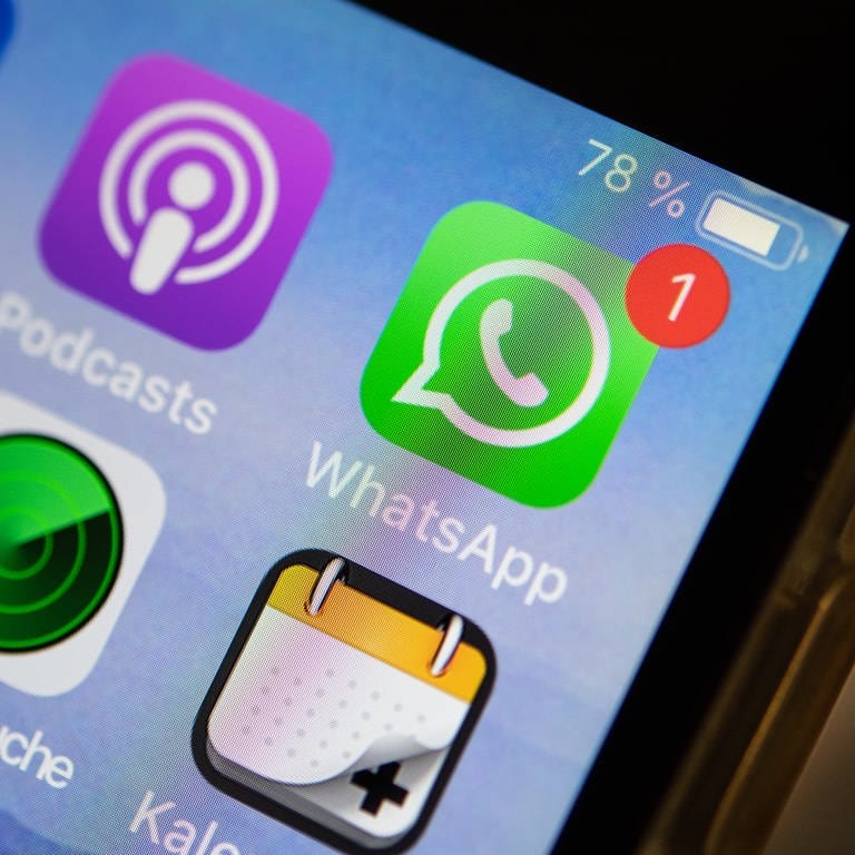 Das Logo der Messenger-App WhatsApp ist auf dem Display eines iPhones zu sehen.