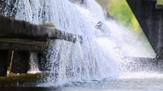 Wasser eines Flusses läuft über ein Wasserwerk