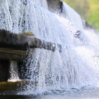 Wasser eines Flusses läuft über ein Wasserwerk