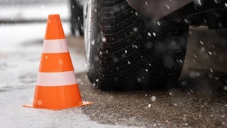 Auto fährt bei Schnee auf der Straße. Wie steht es um die Regel von Sommerreifen und Winterreifen?