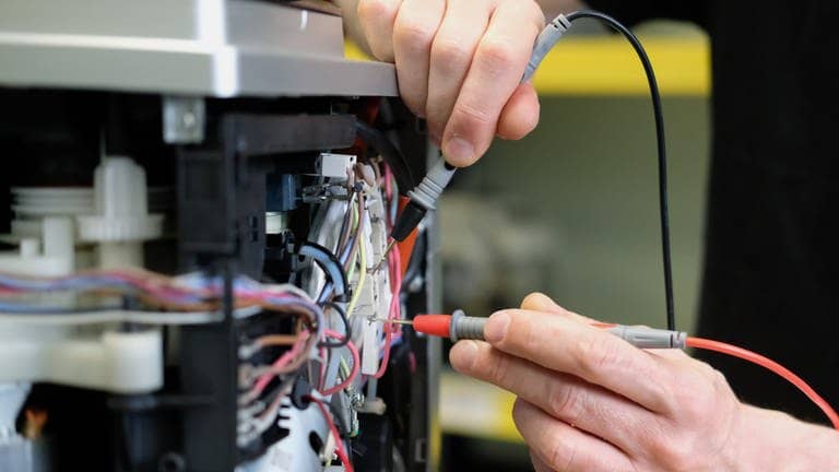 An einem Kaffee-Vollautomaten in einer Reparaturwerkstatt werden elektronische Messgrößen ermittelt. - In der EU soll es ein Recht auf Reparatur geben.