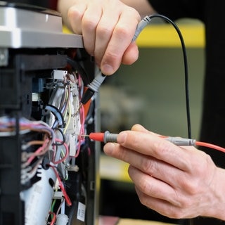 An einem Kaffee-Vollautomaten in einer Reparaturwerkstatt werden elektronische Messgrößen ermittelt. - In der EU soll es ein Recht auf Reparatur geben.
