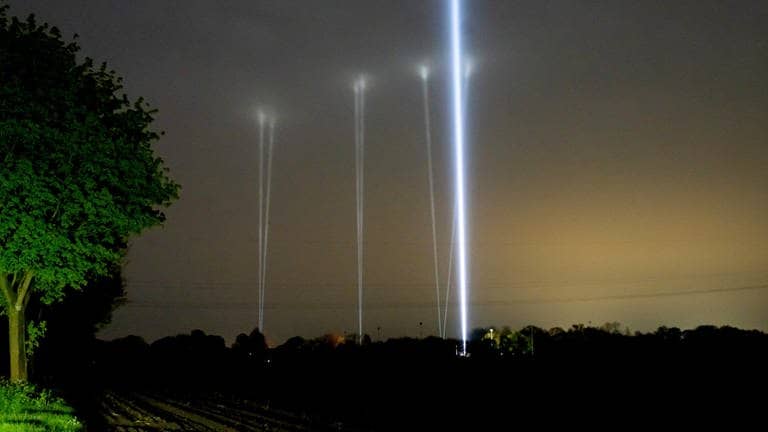 Mehrere Skybeamer leuchten in den Nachthimmel. Sie sollen Arian anlocken. (Foto: dpa Bildfunk, picture alliance/dpa | Jonas Walzberg)