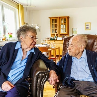 Ursula und Gottfried Schmelzer sitzen in ihrem Wohnzimmer zusammen. Die beiden sind seit 80 Jahren verheiratet.