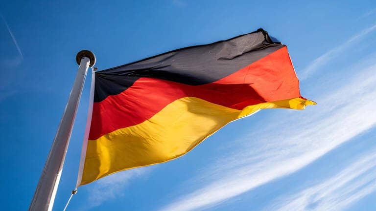 Eine Deutschland-Fahne weht vor einem blauen Himmel