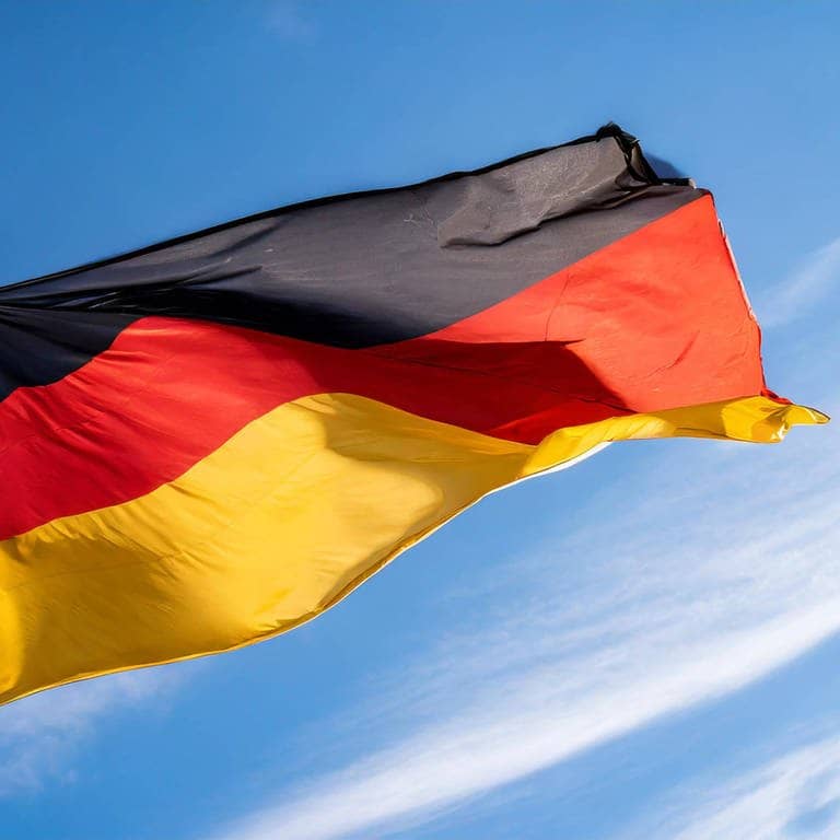 Eine Deutschland-Fahne weht vor einem blauen Himmel
