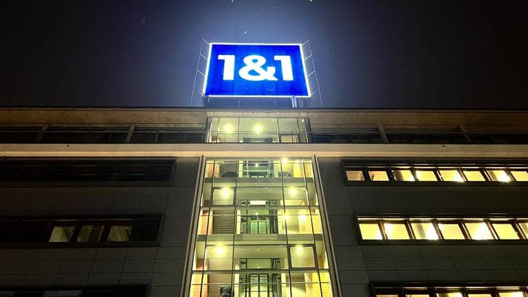 Das leuchtende Logo von 1&1 ist auf dem Dach der Firmenzentrale in Montabaur bei Nacht zu sehen.