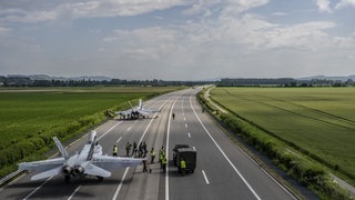 Zwei Kampfflugzeuge vom Typ FA-18 sind auf der Autobahn A1 gelandet und werden gewartet. (Foto: dpa Bildfunk, picture alliance/dpa/KEYSTONE | Peter Schneider) Zwei Kampfflugzeuge vom Typ FA-18 sind auf der Autobahn A1 gelandet und werden gewartet.