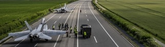Zwei Kampfflugzeuge vom Typ FA-18 sind auf der Autobahn A1 gelandet und werden gewartet.