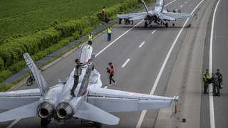 Zwei Kampfjets werden auf der Autobahn A1 gewartet. Die Schweiz übt für den Ernstfall. (Foto: dpa Bildfunk, picture alliance/dpa/KEYSTONE | Peter Schneider) Zwei Kampfjets werden auf der Autobahn A1 gewartet. Die Schweiz übt für den Ernstfall.