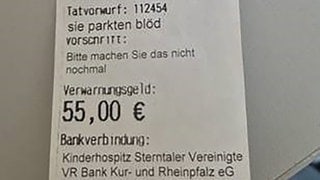 Ausschnitt aus dem "Knöllchen": „Tatvorwurf sie parkten blöd. Vorschrift: Bitte machen sie das nicht nochmal. Verwanungsgeld: 55 €“, eine IBAN sowie der Hinweis auf das Kinderhospitz Sterntaler