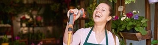 Frau sind mit Gartenschlauch als Mikro: Singen macht glücklich und gesund