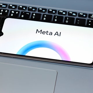 Ein Handydisplay zeigt Meta AI an, eine Funktion, die nun bei Whatsapp, Instagram und Facebook aktiv ist.