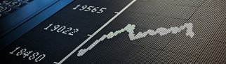 Ein Börsenhändler sitzt an der Frankfurter Börse und die Kurve des Dax zeigt unter 20.000 Punkte an.