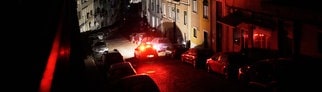 Ein Auto fährt während eines landesweiten Stromausfalls eine unbeleuchtete Straße in Lissabon entlang.