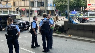 Man sieht einen schwarzen Geländewagen und Polizisten: In der Stuttgarter Innenstadt ist nach Polizeiangaben ein Auto in eine Personengruppe gefahren. Eine Frau ist dabei ums Leben gekommen.