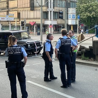 Man sieht einen schwarzen Geländewagen und Polizisten: In der Stuttgarter Innenstadt ist nach Polizeiangaben ein Auto in eine Personengruppe gefahren. Eine Frau ist dabei ums Leben gekommen.