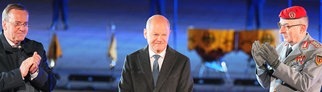 Der scheidende Bundeskanzler Olaf Scholz (M, SPD) lächelt, während Verteidigungsminister Boris Pistorius (l, SPD) und General Carsten Breuer, Generalinspekteur der Bundeswehr, applaudieren, beim großen Zapfenstreich der Bundeswehr anlässlich seiner Verabschiedung.