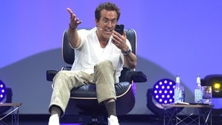 Ryan Reynolds, Schauspieler, Unternehmer und Mitbesitzer des walisischen Fußballclubs Wrexham AFC, telefoniert auf der Bühne mit seinen Kindern während der Digital- und Marketingmesse OMR in den Messehallen.