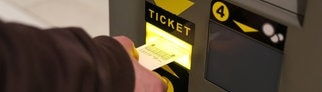 Person zahlt an Parkautomat im Parkhaus