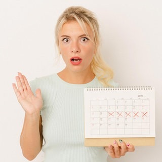Eine Frau hält geschockt einen Kalender in der Hand. Ein Verband will Feiertage streichen.